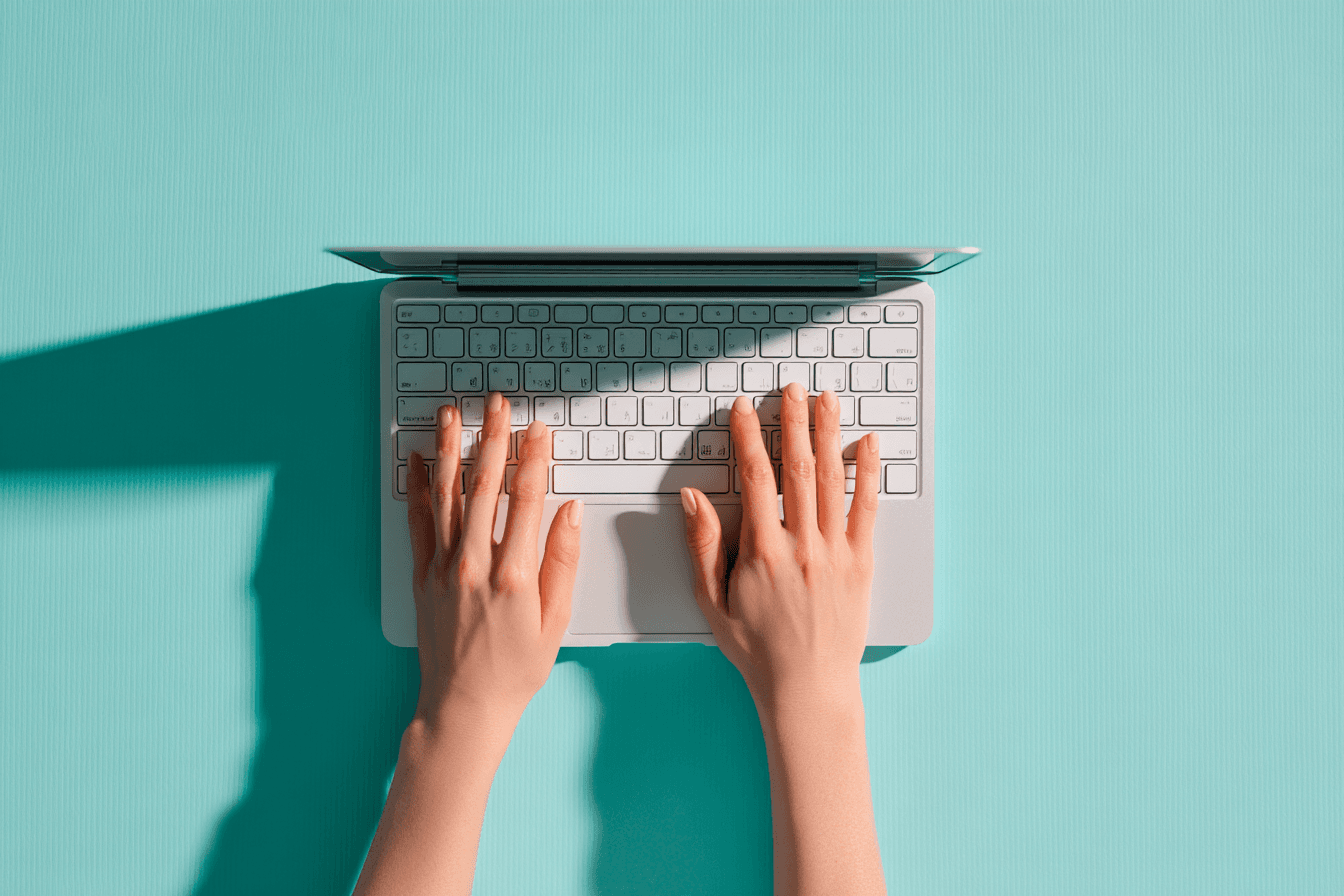 Hands typing on laptop keyboard
